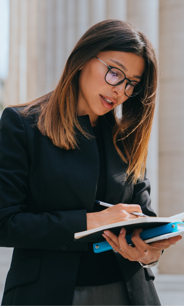 female lawyer takes notes outside of courtroom